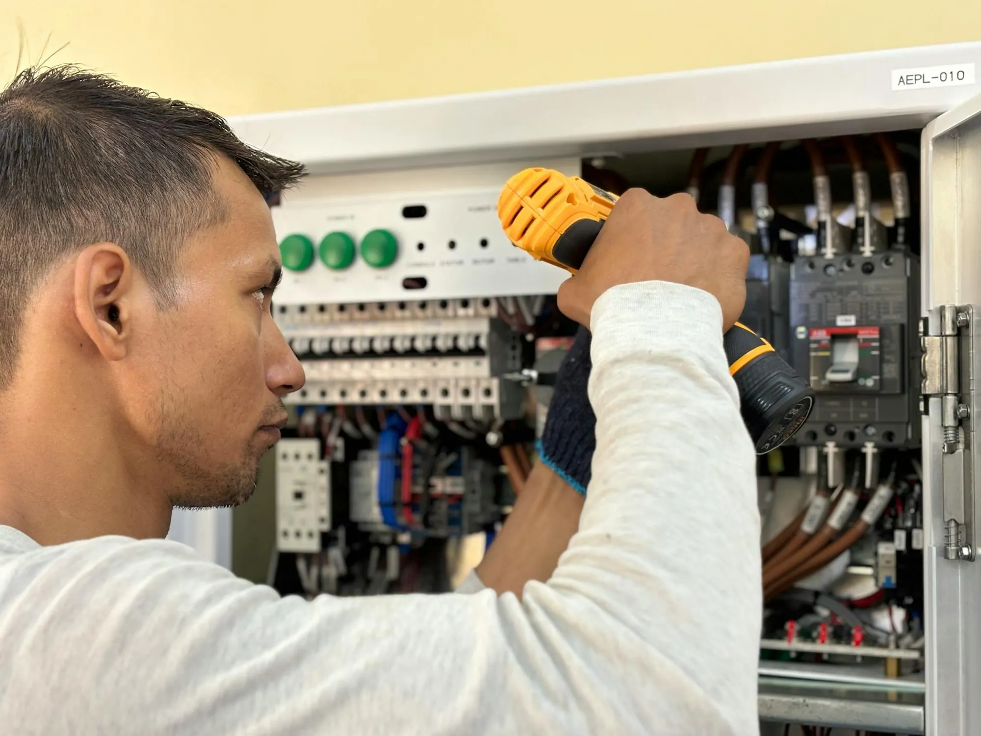 Electrician working on a commercial control panel